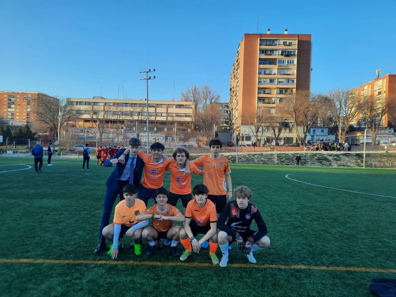 Equipo con camiseta naranja posando